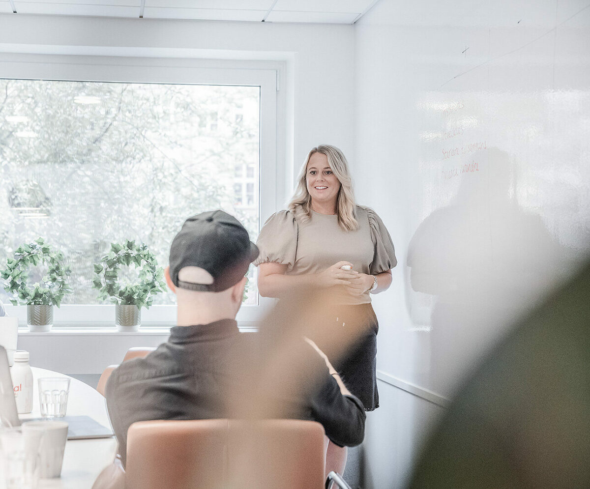 kvinna som står framför en sittande man