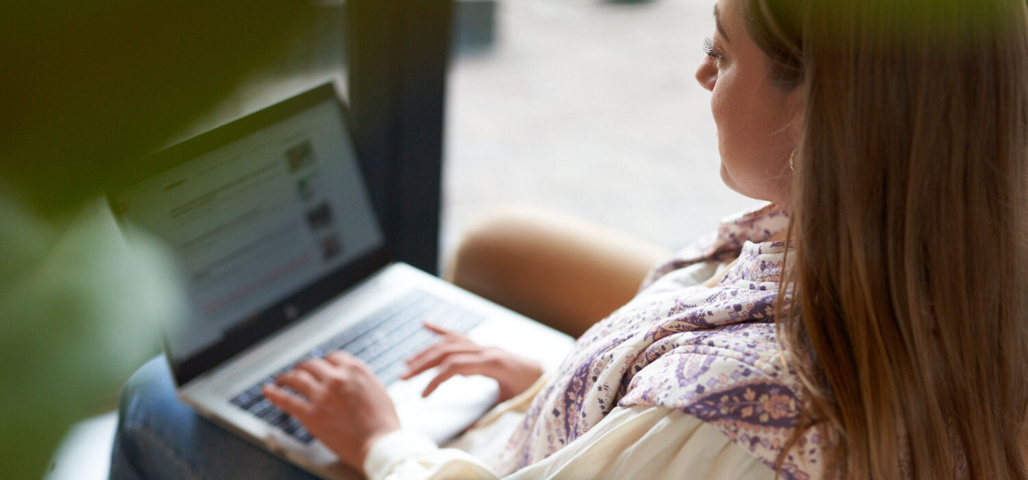 Kvinna sitter med en laptop i knät